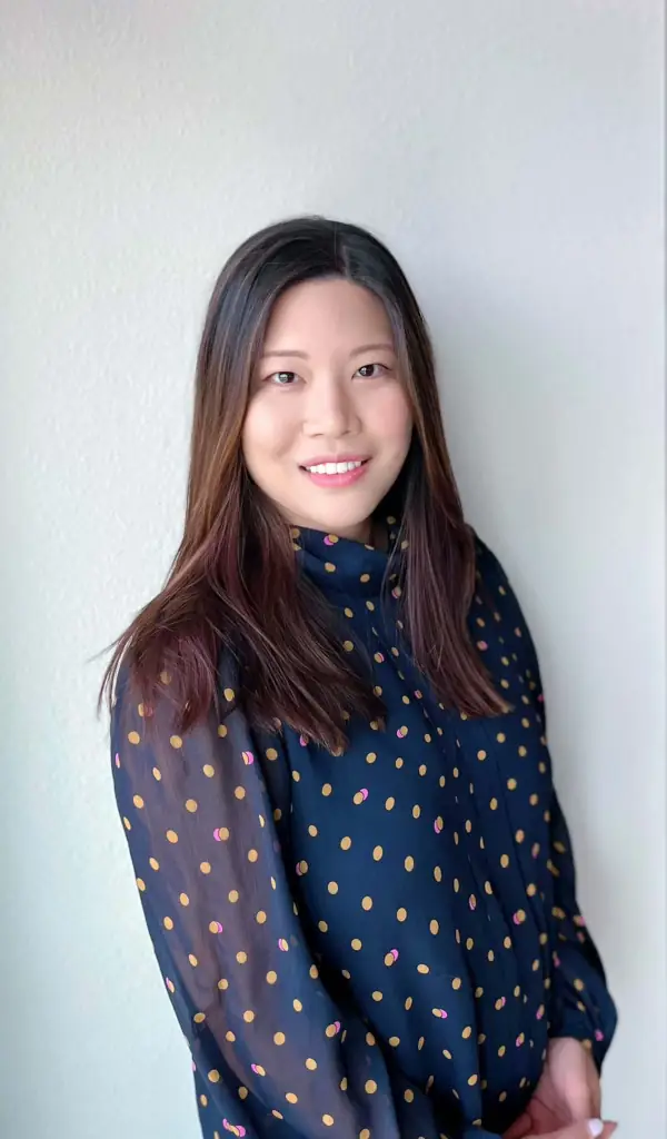 Headshot of Dr. Bae wearing blue tops with orange polka dots and a light background.